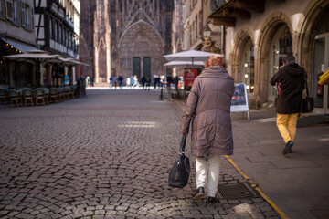 Woman in front of the cathedral - Strasbourg - obrazy, fototapety, plakaty