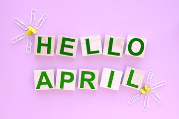 hello april. text of wood cubes on a pink background