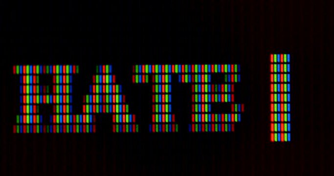 The word hate is written in pixel letters on the monitor. RGB font rendering. The designation of a mental state. Dark background. The cursor is blinking.