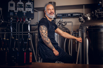 Grandfather brewing business man with tattooed hand in brewery