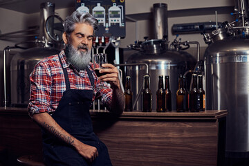 Grandfather businessman with beer glass inside his modern brewery