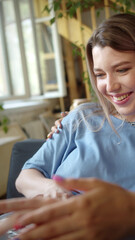 Two young beautiful ladies are searching through the Internet on the laptop, discussing and smiling