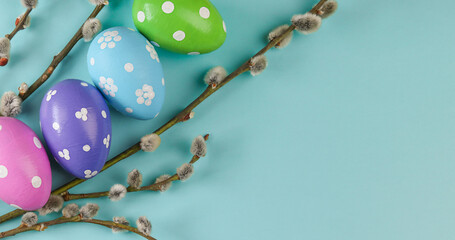 Easter eggs  with willow branches on blue background. Flat lay top view with copy space. Happy Easter holiday.
