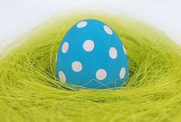 Blue Easter egg  lie in a nest isolated on white background. Happy Easter holiday. Minimal concept for Easter.