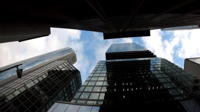 Frankfurt am Main, Germany, December 7, 2021: SLOW - Skyscrapers and commercial buildings in the financial district of Frankfurt. Tall glass buildings. View of tall modern buildings from the ground.