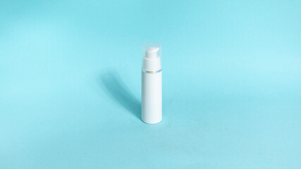 One white tube of skin care cosmetics on blue background. The concept of face and body skin care and anti-aging treatments.