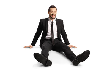 Businessman sitting on ground and smiling