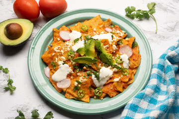 Red chilaquiles with cheese and avocado. Mexican food