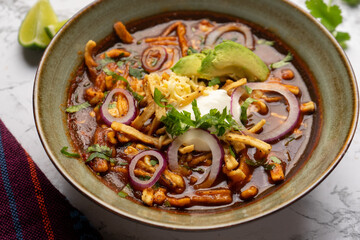 Tortilla soup with avocado and cheese. Mexican food