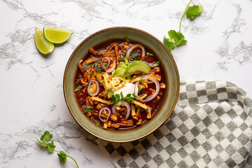 Tortilla soup with avocado and cheese. Mexican food