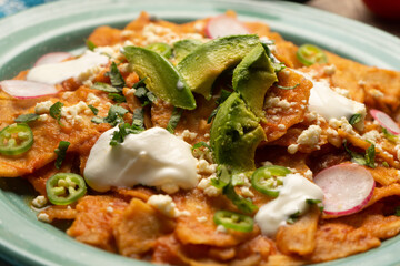 Red chilaquiles with cheese and avocado. Mexican food