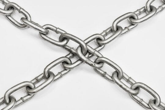 Old metal chain cross on white background. Concept of imprisonment, incarceration, detention, ban, isolation, lock.