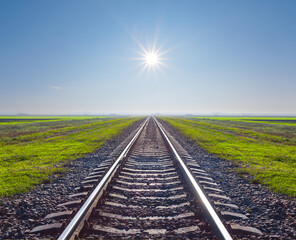 railway among green plain under a sparkle sun