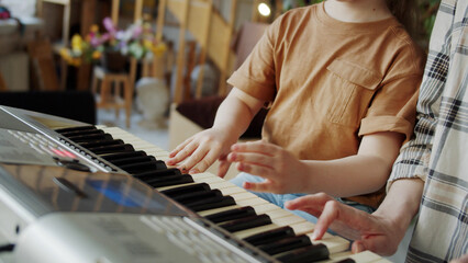 Mom and daughter play the piano peacefully