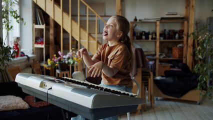 Obraz na płótnie Canvas Girl fooling around playing the synthesizer