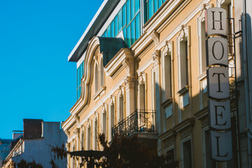 Beautiful architecture building on sunlight in Sofia, Bulgaria. Big hotel sign on the wall. Urban city life. High quality photo