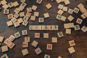 A word CRISIS composed of aligned wooden blocks with letters vocabulary game economical problems...