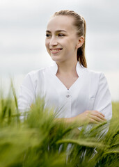 Portrait of Ecologist or biologist in a white coat and glasses examining plants
