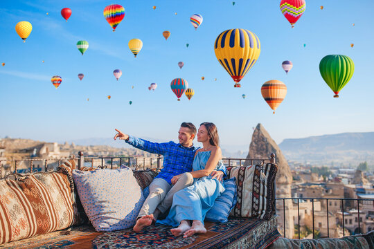 Happy young couple during sunrise watching hot air balloons in Cappadocia, Turkey