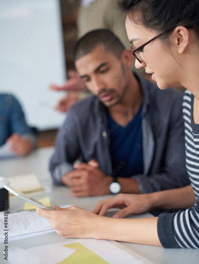 Aufkleber putting two heads together. shot of two coworkers sitting at a table in an office using a digital ta