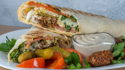 Plate of falafel with pita bread, vegetables and tzatziki sauce. Arabian meal, hummus and falafel.