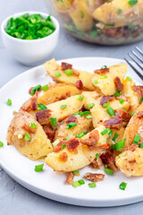 Bacon and onion potato salad dressed with apple cider vinegar and mustard, on plate, vertical