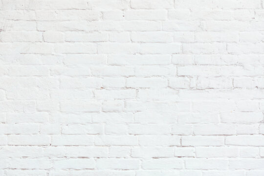 White brick wall with cracks, cement, stucco. Can be used as a poster or background for design. 