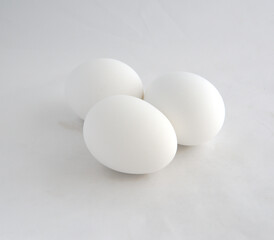 Three white chicken eggs ready to be decorated for a holiday.
