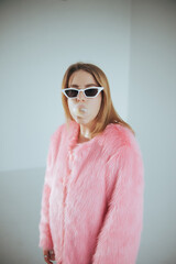 Fashion model in pink suit and sunglasses. Studio shot. Film edit