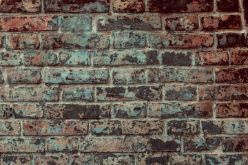 Black grungy brick wall. Free space for an inscription. Can be used as a background or poster. Fragment of a wall with bumps and peeling paint.