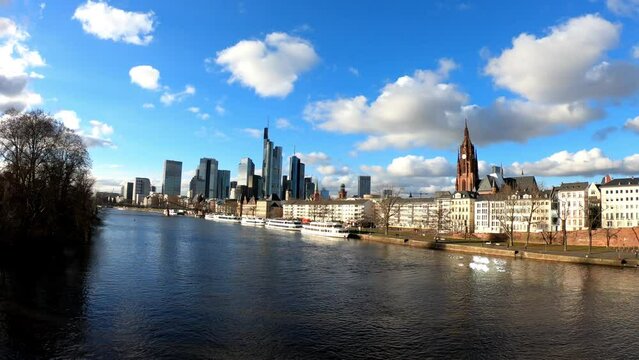 PAN SLOW - Business corporate downtown bank district with high tall skyscraper buildings, Saint Bartholomeus's Cathedral, and Eiserner Steg bridge over the Main River in Frankfurt am Main, Germany.