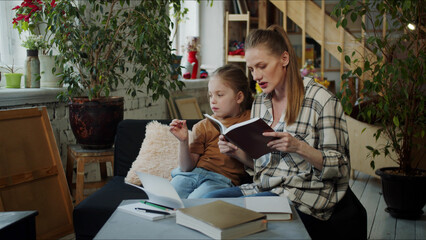 A woman is reading a book to a girl. Teenager messing around