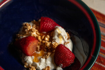 Top View Dessert of fresh strawberries on granola and yogurt with honey