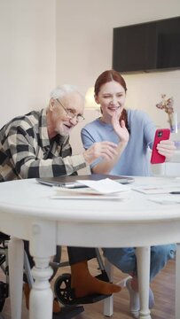 Grandfather and his adult granddaughter communicate with the family via video communication on the phone