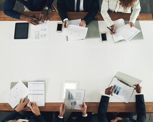 Looking at ways to upgrade the business. High angle shot of a team of businesspeople working around...
