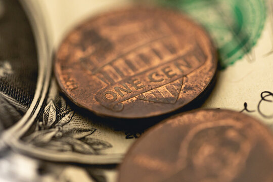 Nota de 1 Dólar dos Estados Unidos com moedas em fotografia macro. Conceitos de economia e finanças. Foco na moeda de 1 centavo de dólar.