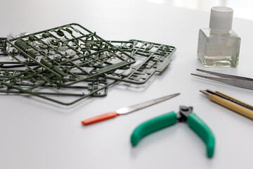 テーブルの上のプラモデルのパーツと工具類	