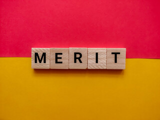 Alphabetical letters with the word Merit on a red and yellow background. Business and merit concept