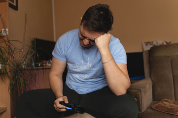 Fototapeta premium A one man playing video games in his room during the day