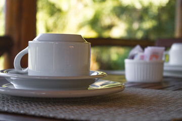 Mesa de Café da manhã com xícara de café ou de chá com um ambiente emadeirado e com verdes