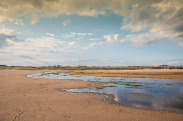blue stream running in the sand in praia do  cassino , rio grande do sul