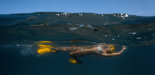Woman floating underwater in mask