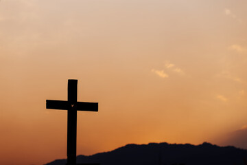 Silhouette of cross on mountain at sunset. concept of religion.