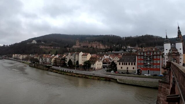 Heidelberg, Germany, December 9, 2021: PAN SLOW MOTION SHOT - The Church of the Holy Spirit, the Heidelberg Palace and Karl Theodor Bridge with Stadttor gate, Baden Wurttemberg, Germany. 