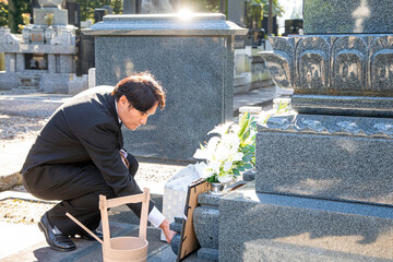 納骨・お墓参りをする遺族（水）
