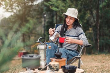 Hipster asian woman camper relaxing and enjoying camping alone ,cooking for breakfast in the morning