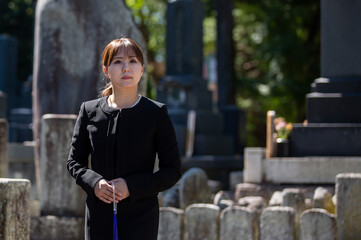 お葬式・お墓参りする喪服姿の若い女性

