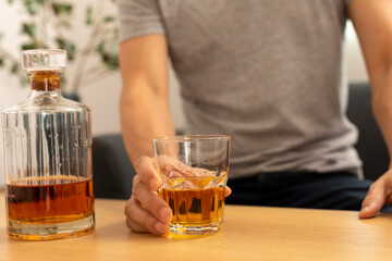 Alcohol addicted man sleeping at the table. Sad depressed male adult having troubles with alcohol.