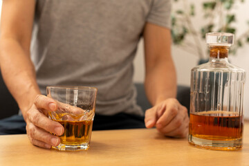 Alcohol addicted man sleeping at the table. Sad depressed male adult having troubles with alcohol.