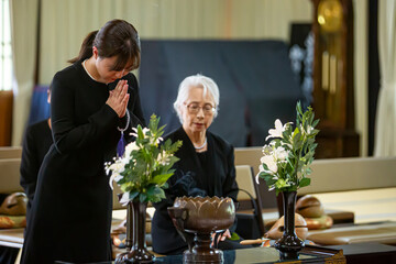 お葬式で焼香台に立つ女性（お焼香）
